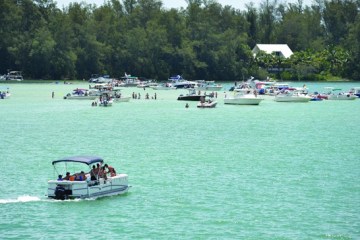 Back view of boat rental with happy family visitng the crystal blue clear waters at Jewfish Key